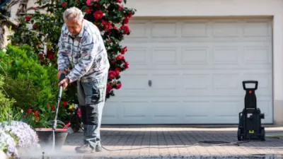 Senior using pressure washer